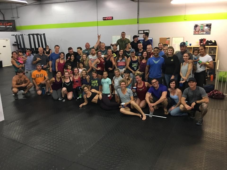 A group of people are posing for a picture in a gym.