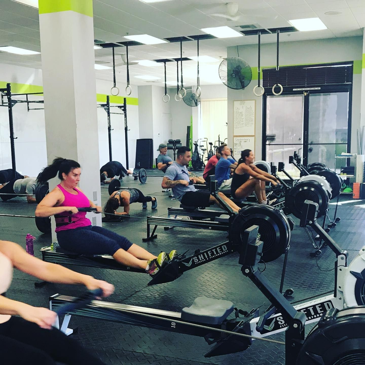 A group of people are using rowing machines in a gym