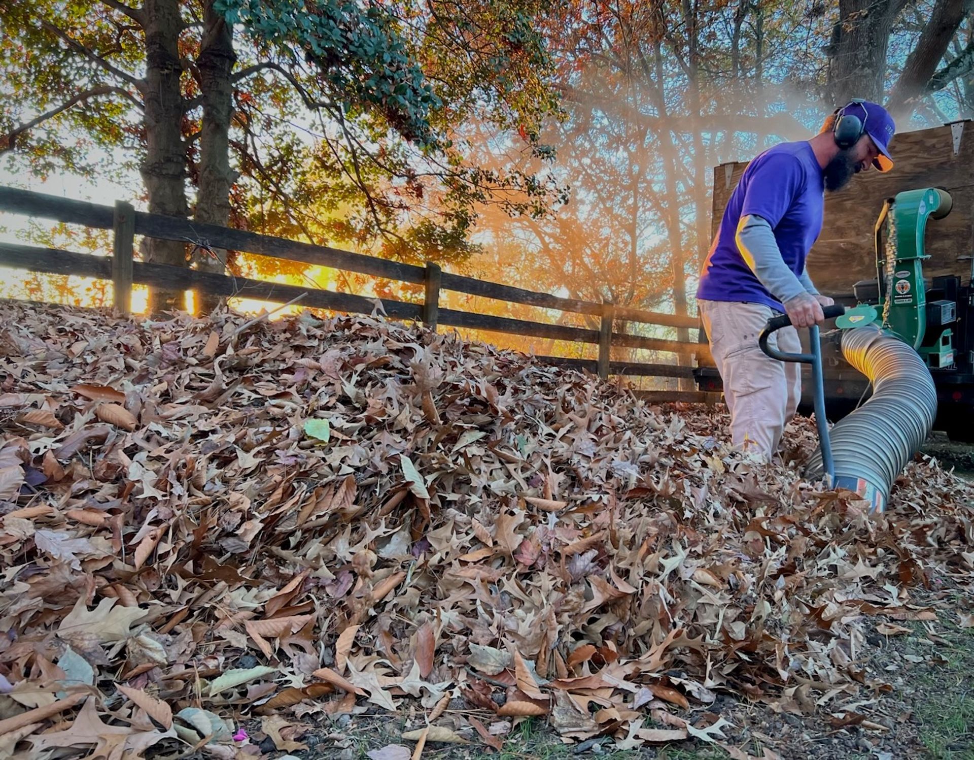 A man is blowing leaves from a pile of leaves.