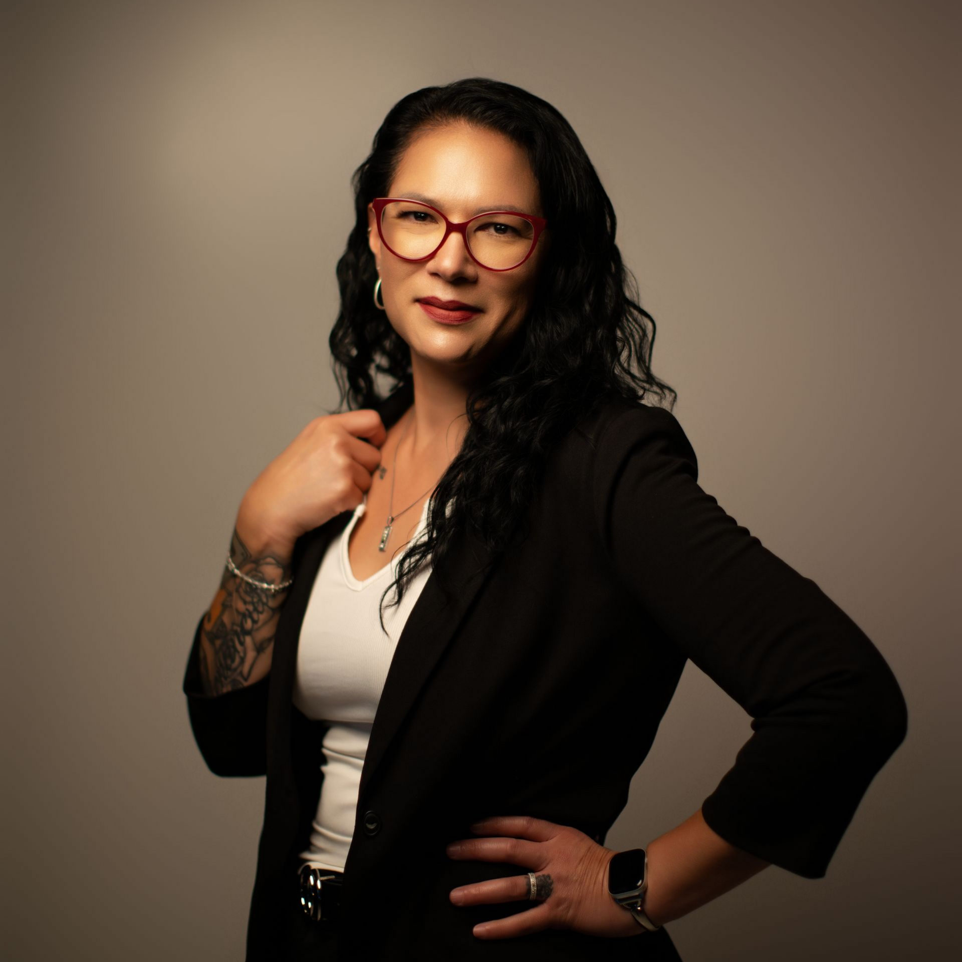 A man in a suit and white shirt is standing in front of a white background.