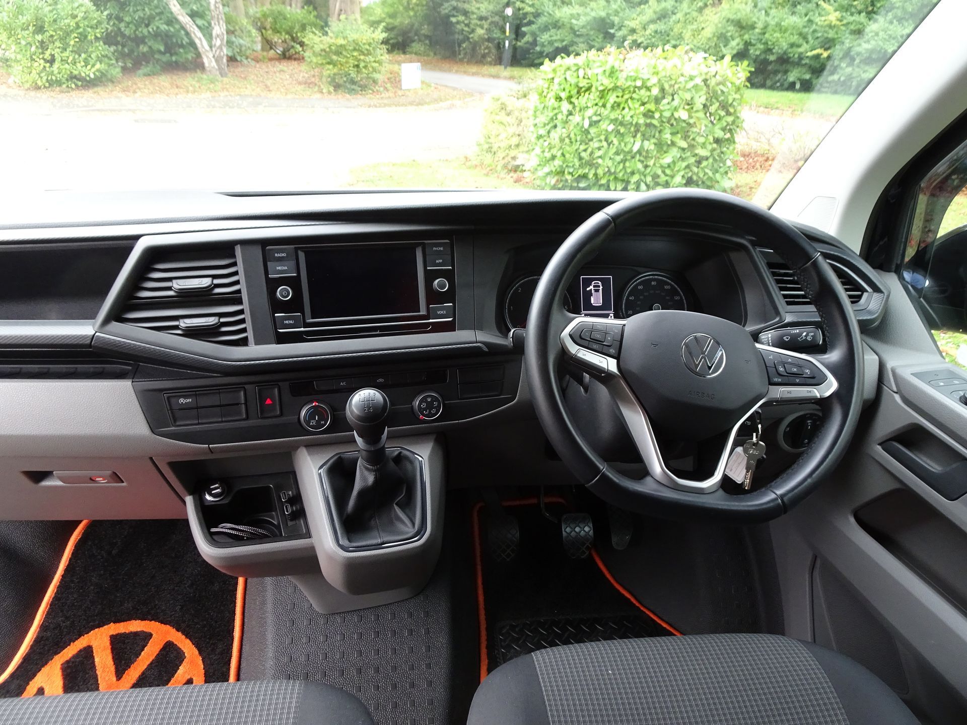 The interior of a volkswagen van with a steering wheel and dashboard