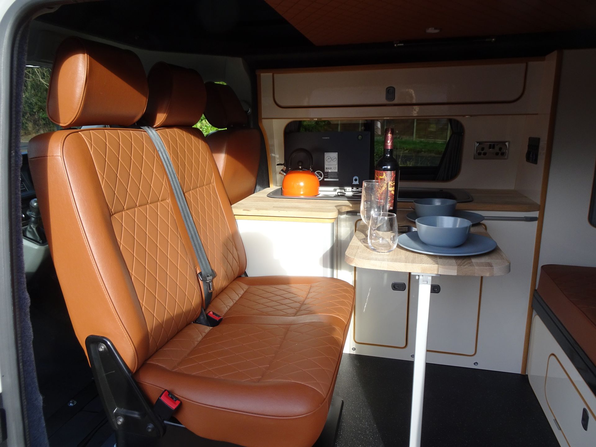 The inside of a van with brown seats and a table