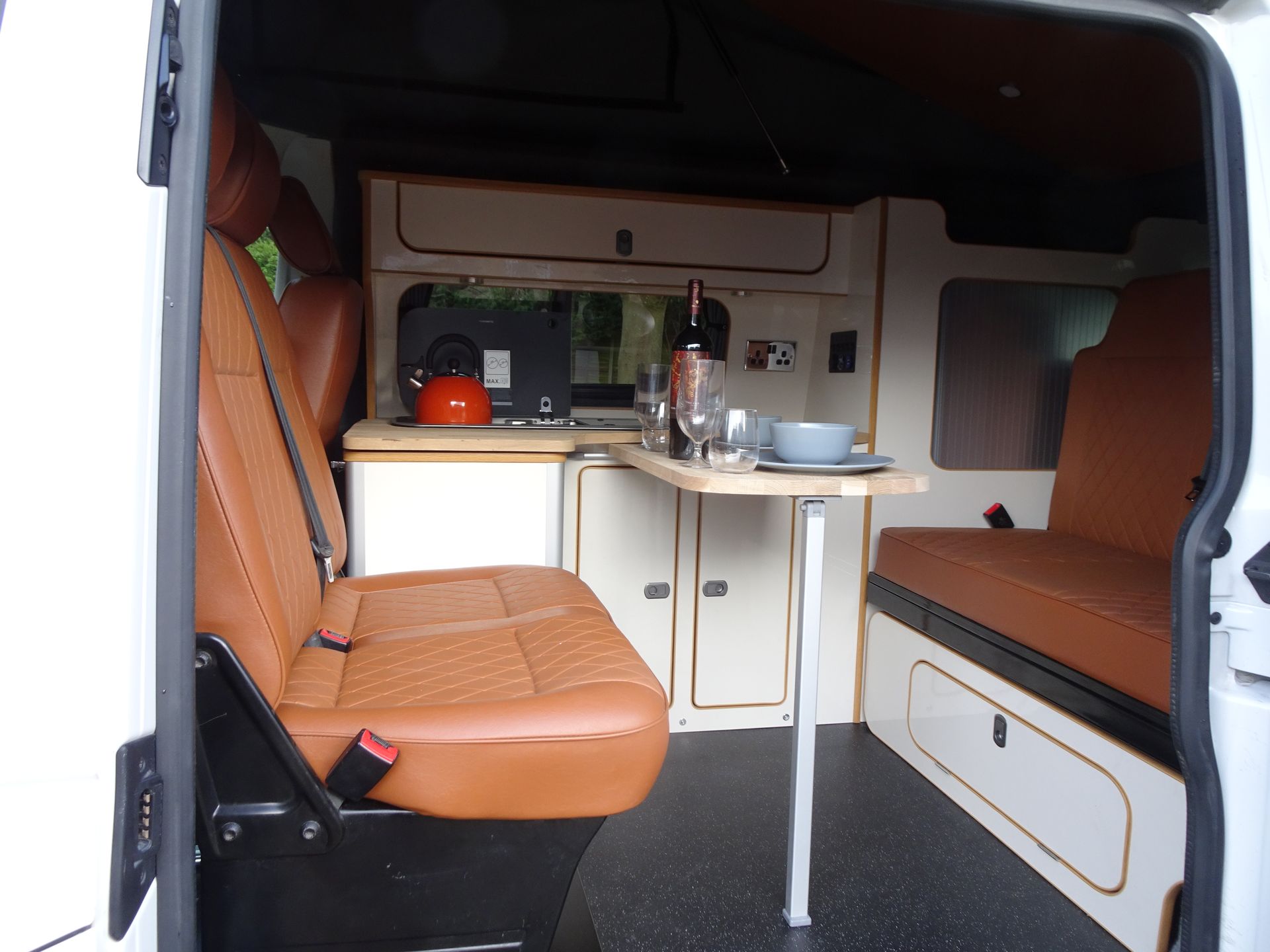 The inside of a white van with brown seats and a table