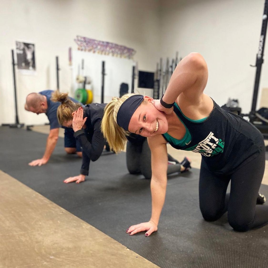 A group of people are doing push ups in a gym