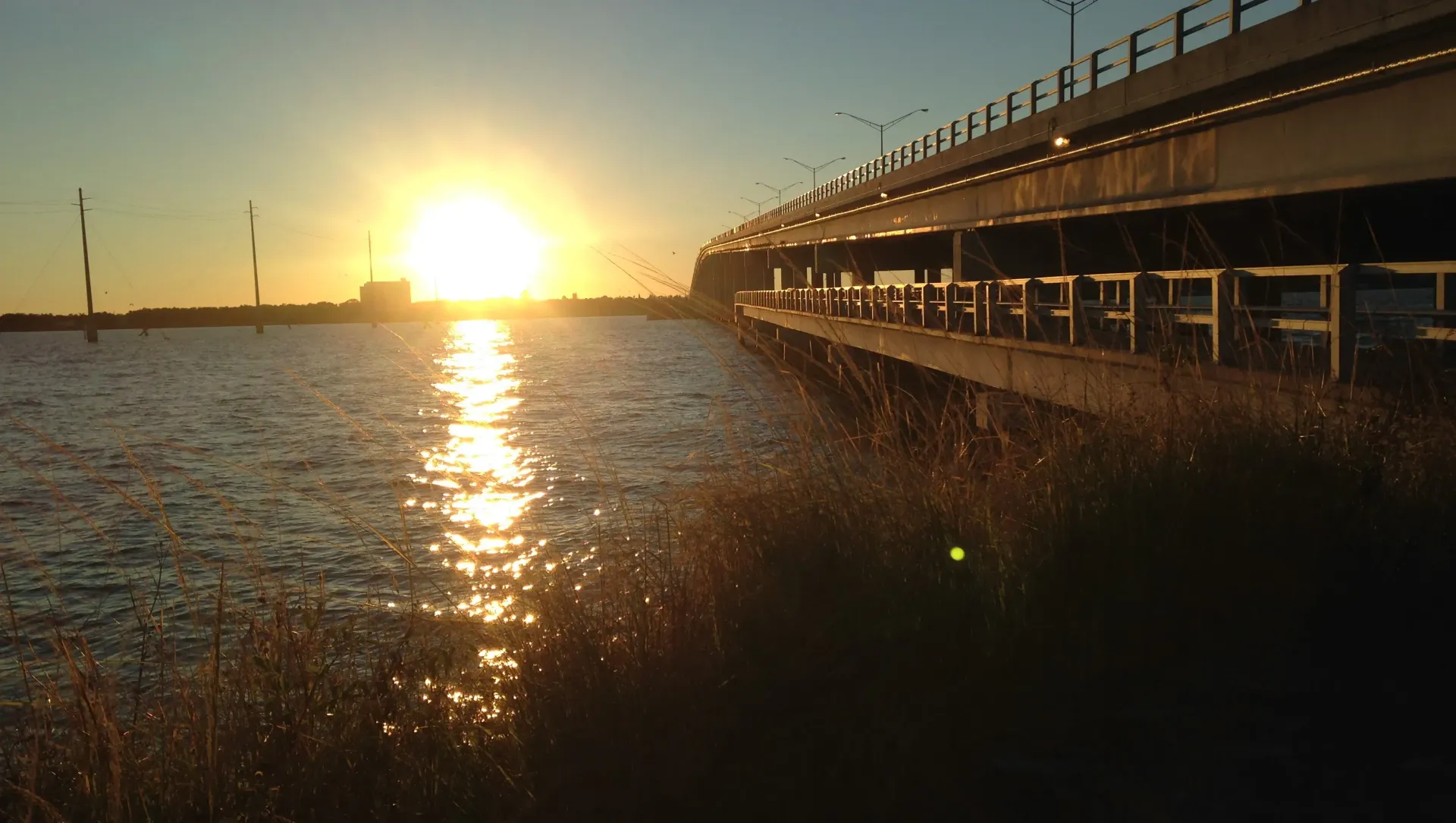 A pier leading into the ocean at sunset