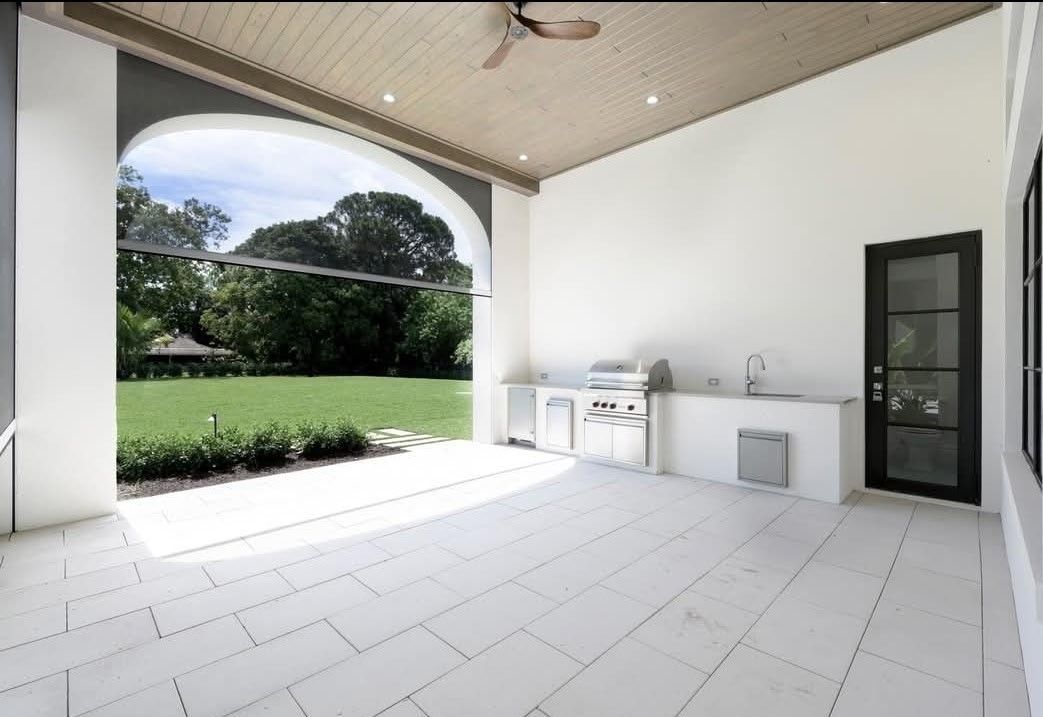 There is a swimming pool in the backyard with a screened in area.