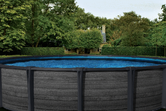 Above-ground pool in a backyard surrounded by green trees and hedges