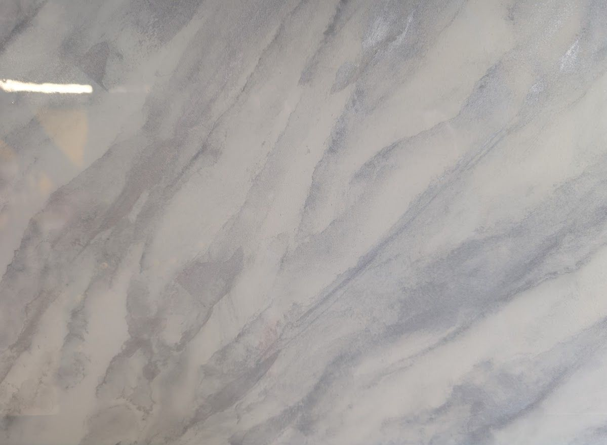 White and gray marble surface with swirling patterns.