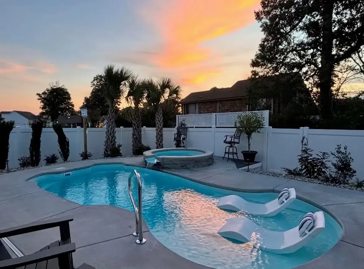 A screened in porch with a brick house in the background.