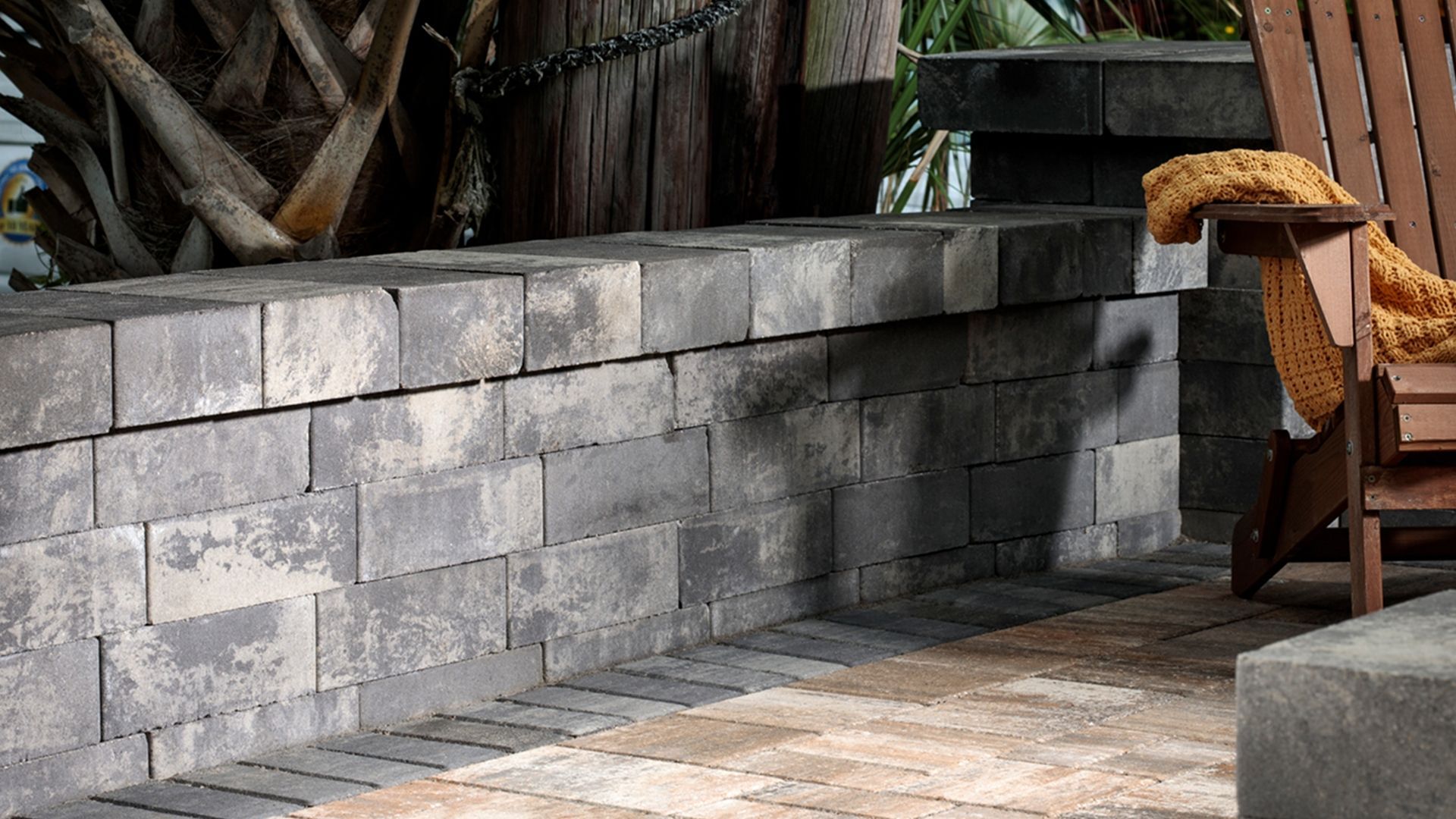 A screened in porch with a brick house in the background.