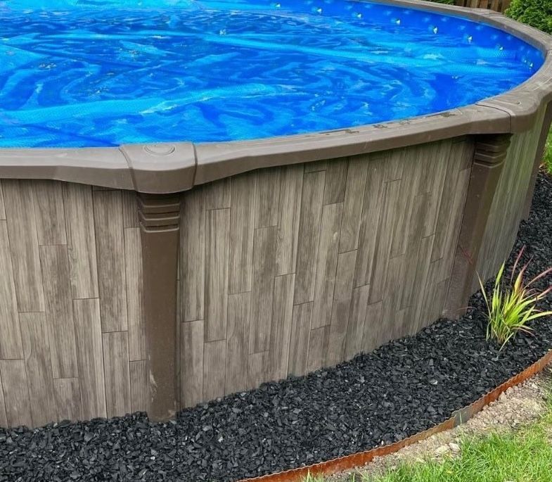 Premium above-ground pool with wood-grain resin walls installed by Right Way Enclosures in a landscaped Vero Beach backyard on the Treasure Coast.