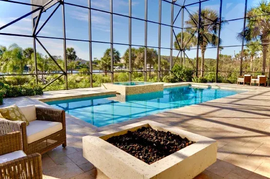 Custom concrete pool with fire pit and hurricane-rated screen enclosure built by Right Way Enclosures in Vero Beach, Florida.