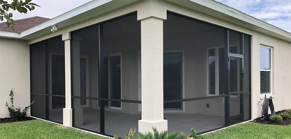 A screened in porch with a swimming pool in the background