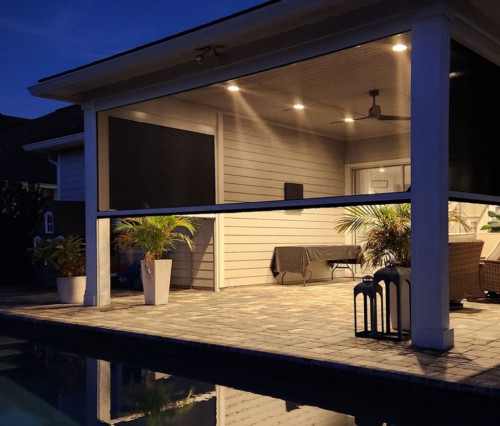 A screened in porch with a swimming pool in the background