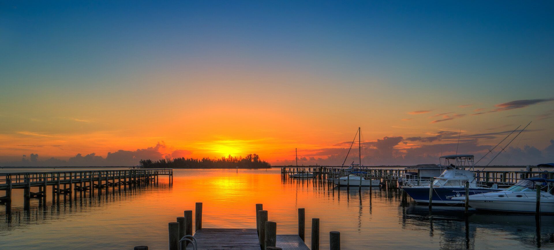A pier leading into the ocean at sunset