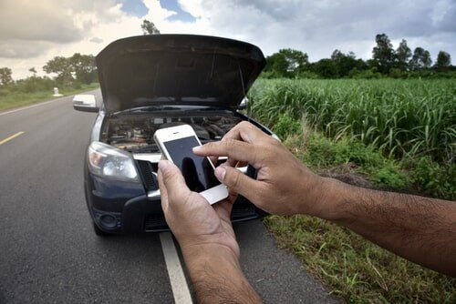 Driver calling a mobile mechanic after breaking down on a rural road