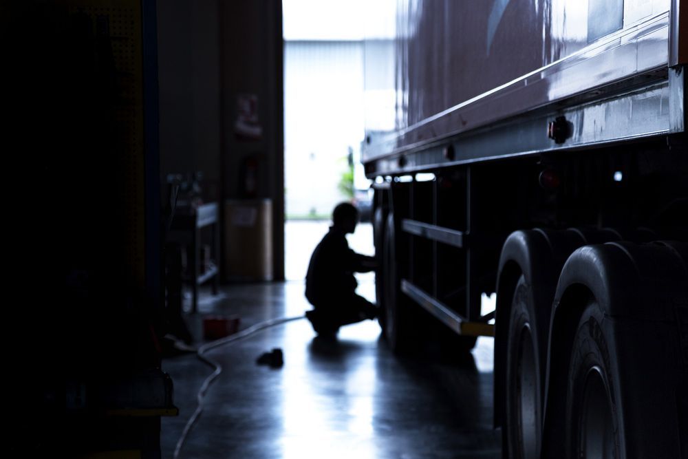 Silhouette of an Automobile Mechanic Checking a Truck in the Garage — Truck Trailer Repairs in the Illawarra