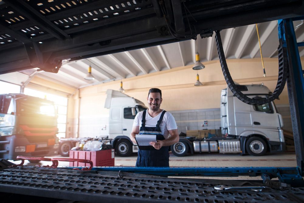 Smiling Mechanic Standing In Truck Repair Shop — Complete Truck Repairs in the Illawarra