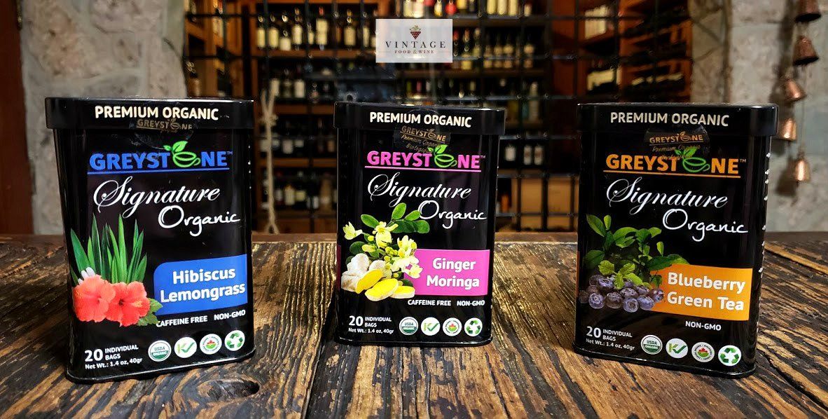 Hay tres cajas de té sobre una mesa de madera.