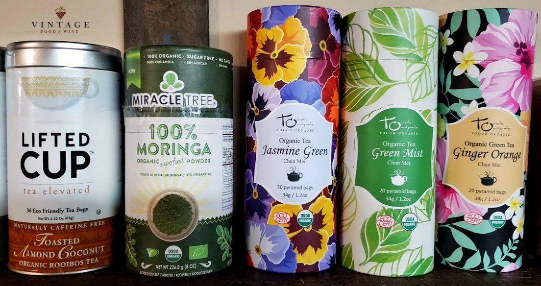 Un grupo de latas de té están colocadas una al lado de la otra sobre una mesa.