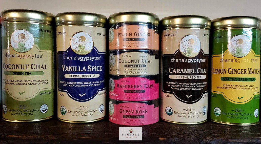 Una fila de latas de diferentes sabores de té están apiladas una encima de otra sobre una mesa.