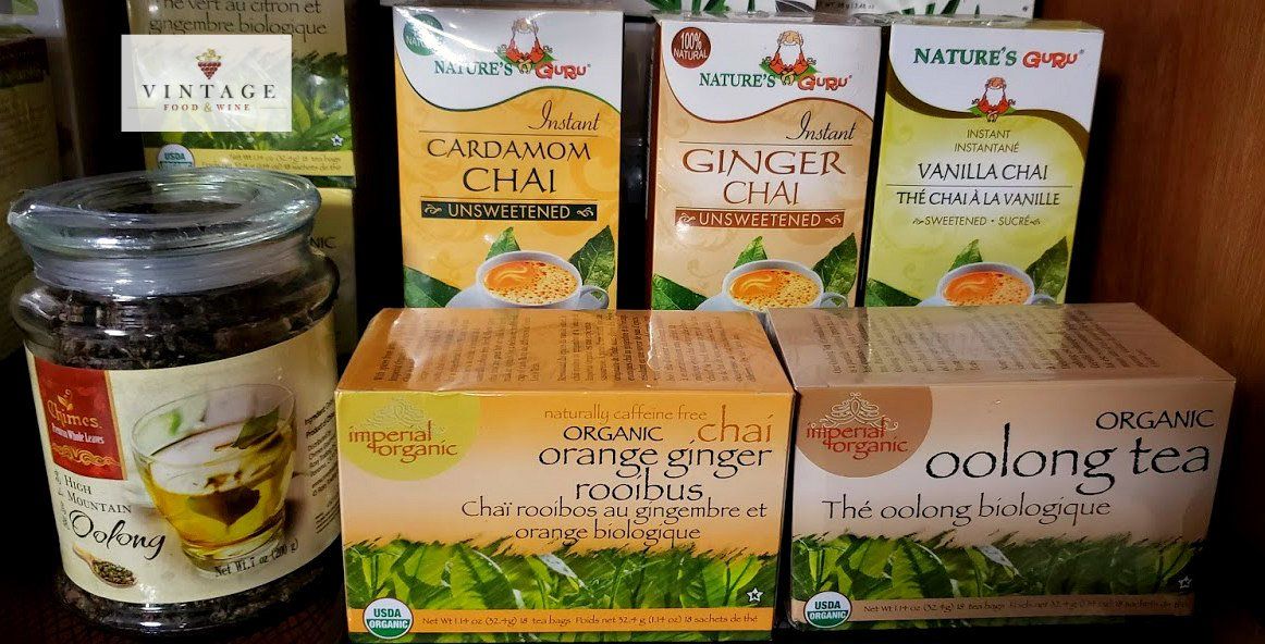 Una jarra de té y cajas de té están sobre una mesa.