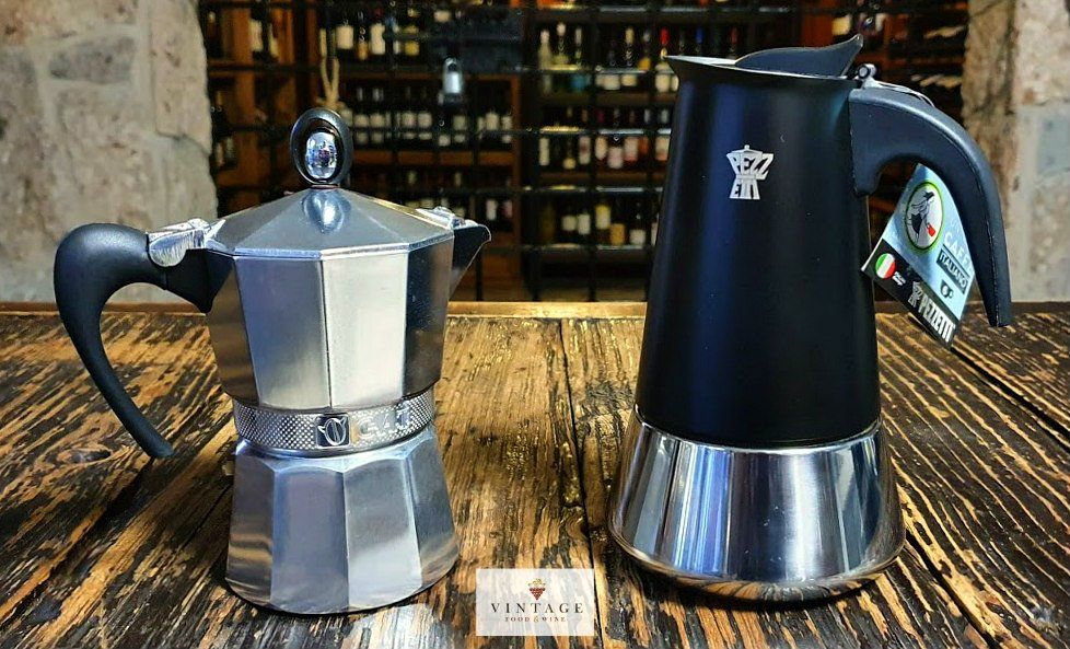 Hay dos cafeteras sobre una mesa de madera.