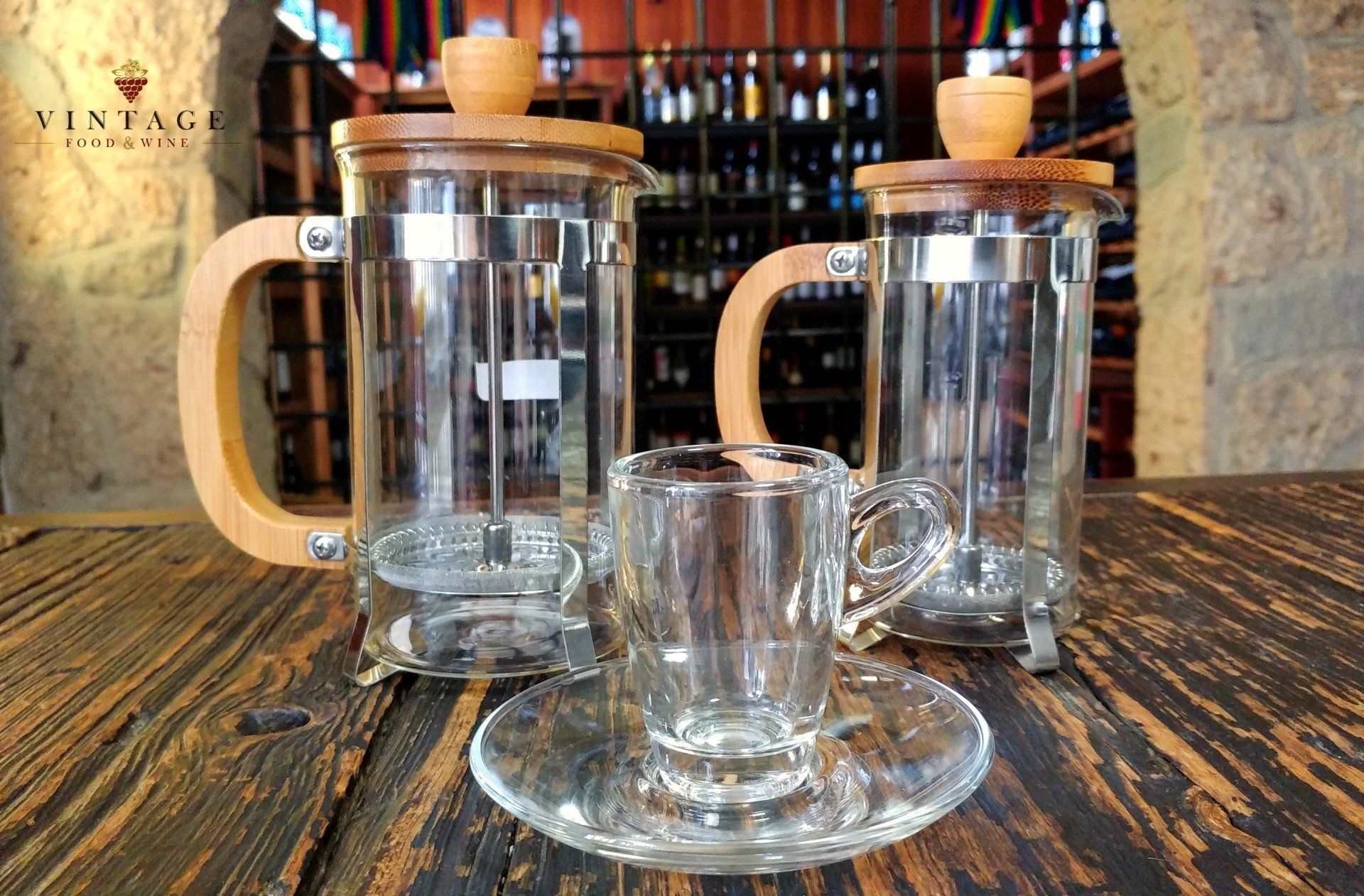 Tres tazas de vidrio y platillos están sobre una mesa de madera.