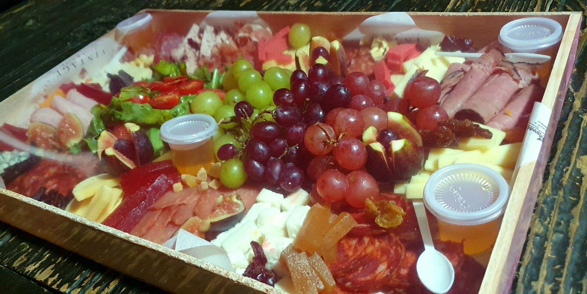 Una caja de madera llena de una variedad de frutas y carnes.