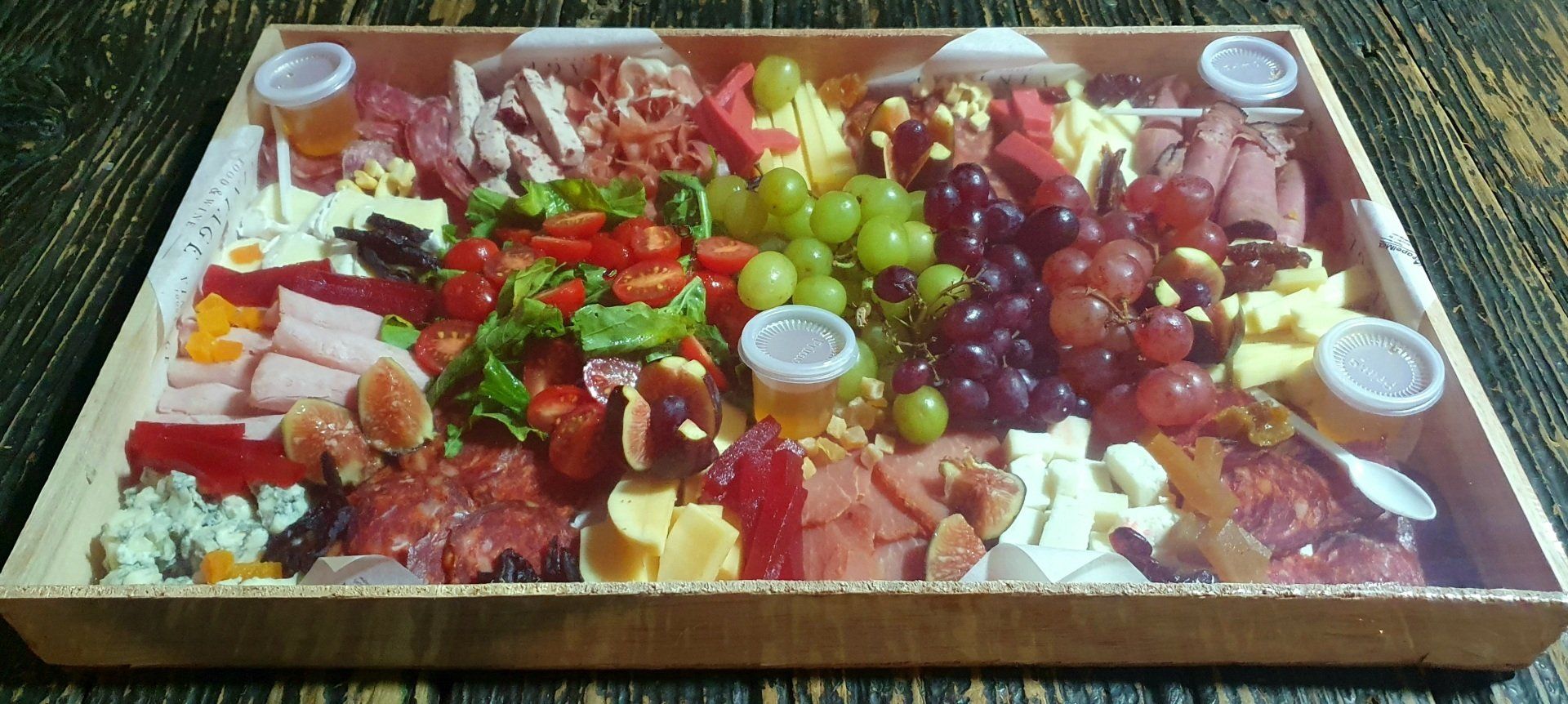 Una caja de madera llena de una variedad de frutas y carnes.