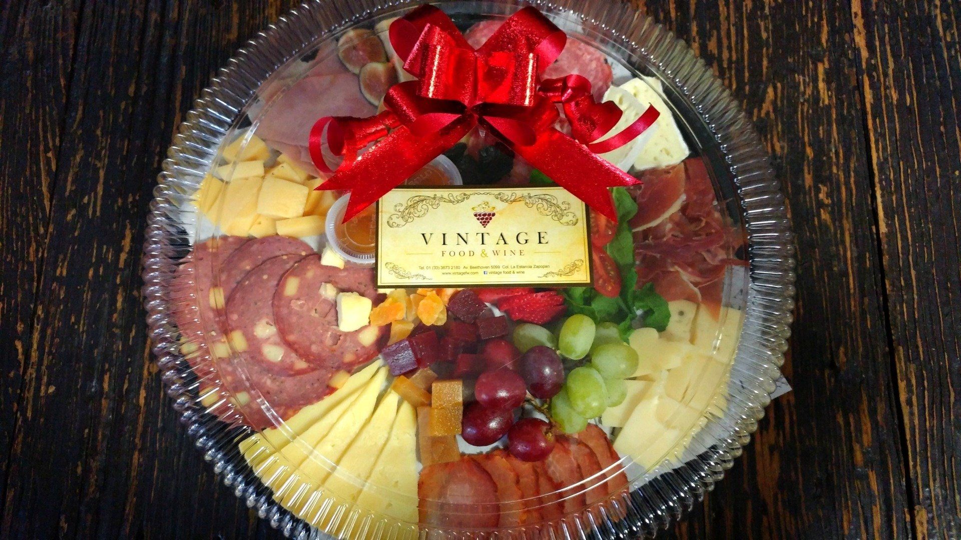 Una bandeja de comida con un lazo rojo sobre una mesa de madera.