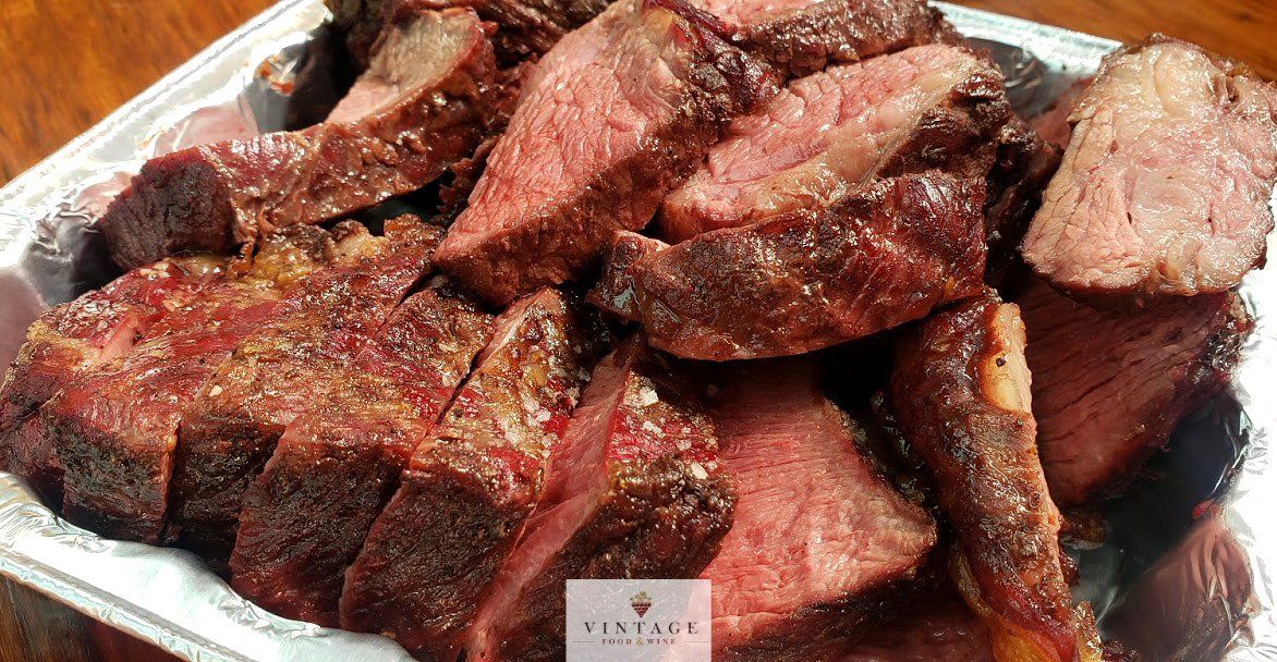 Una bandeja de carne está sobre una mesa de madera.