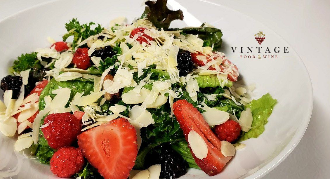 Una ensalada con fresas y almendras en un plato blanco.