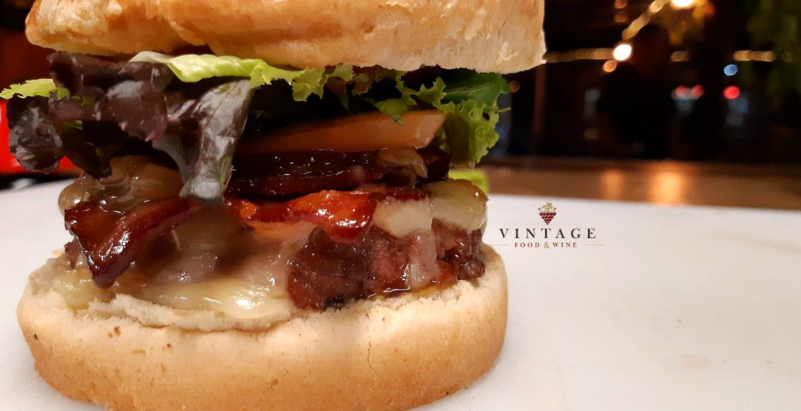 Un primer plano de una hamburguesa en un plato blanco.