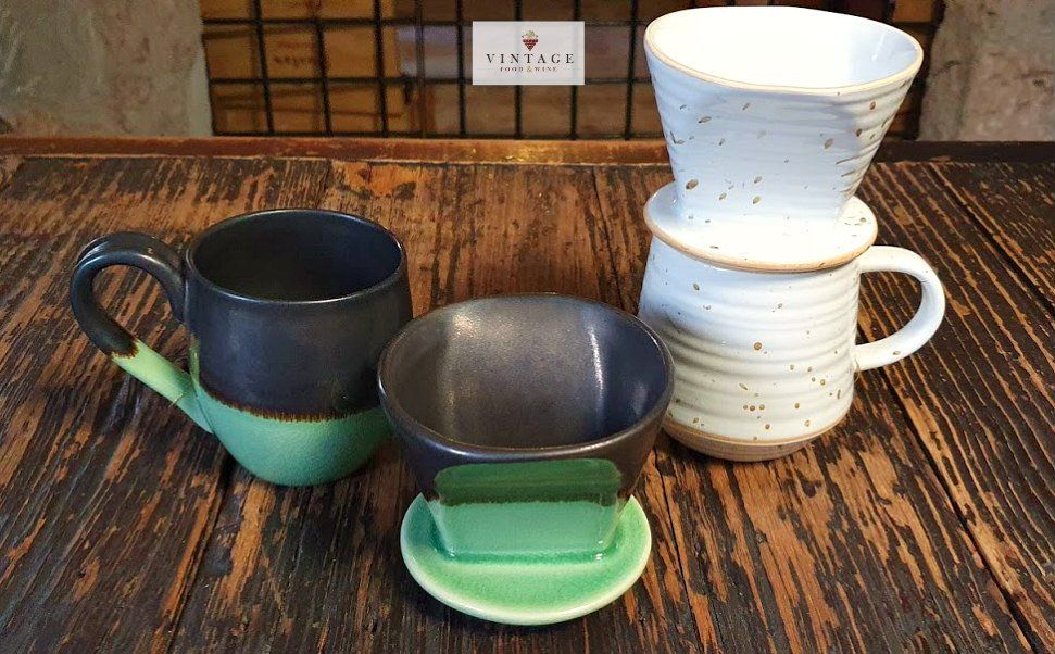 Un grupo de tazas de café están sobre una mesa de madera.