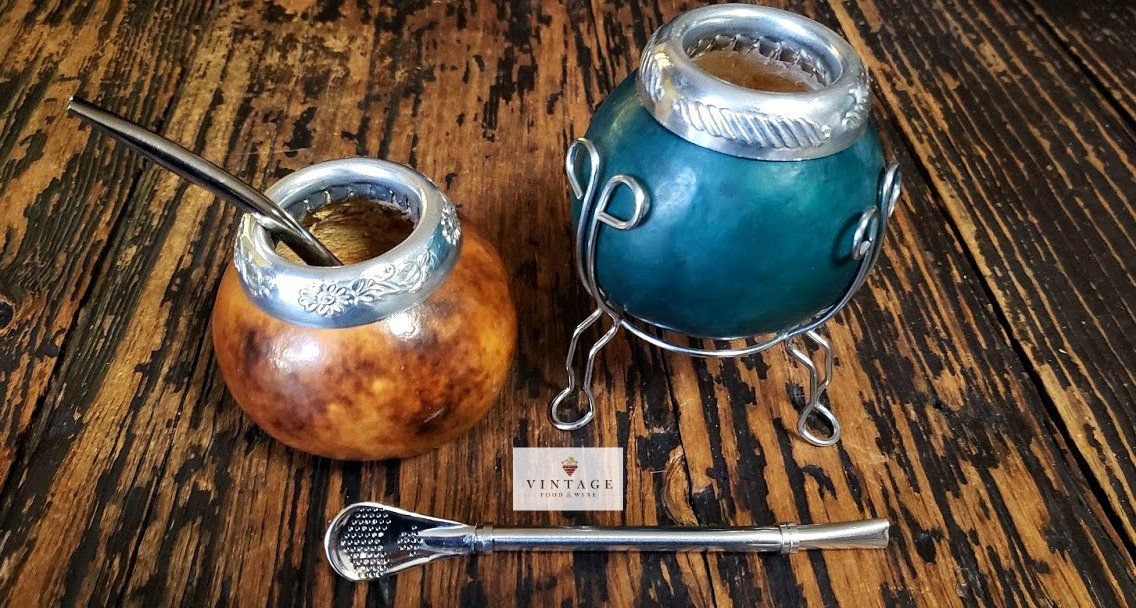 Dos tazas de calabaza con cucharas sobre una mesa de madera.