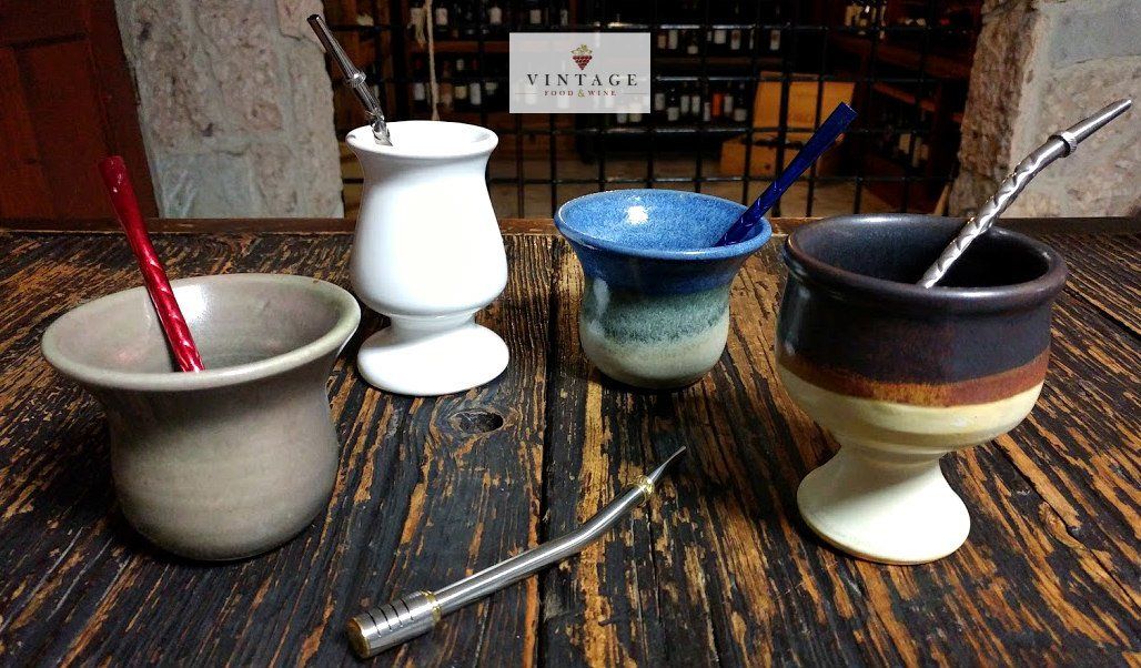 Un grupo de tazas con pajitas sobre una mesa de madera.