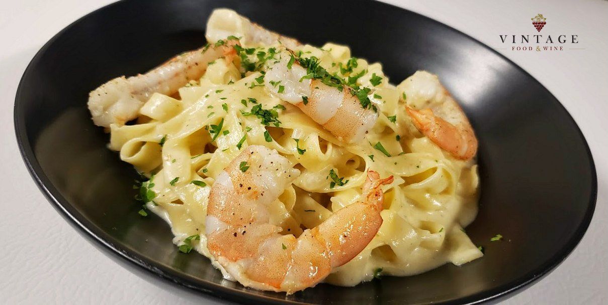 Un primer plano de un plato de pasta con camarones.