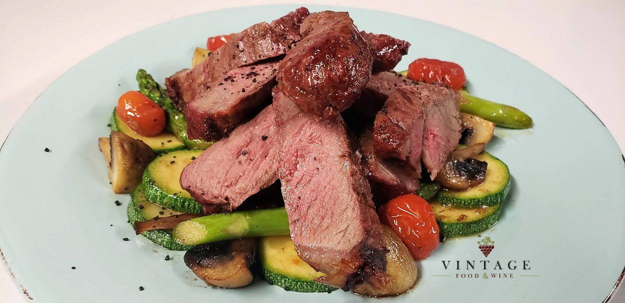 Un plato de comida con carne y verduras en una mesa.