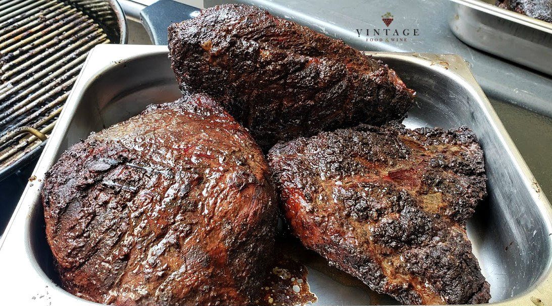 Una sartén de metal llena de filetes se encuentra sobre una mesa.