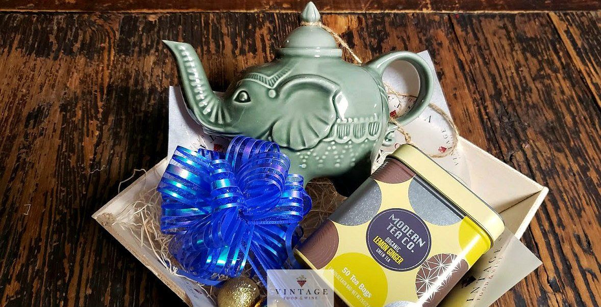 Una tetera con forma de elefante está colocada encima de una mesa de madera.