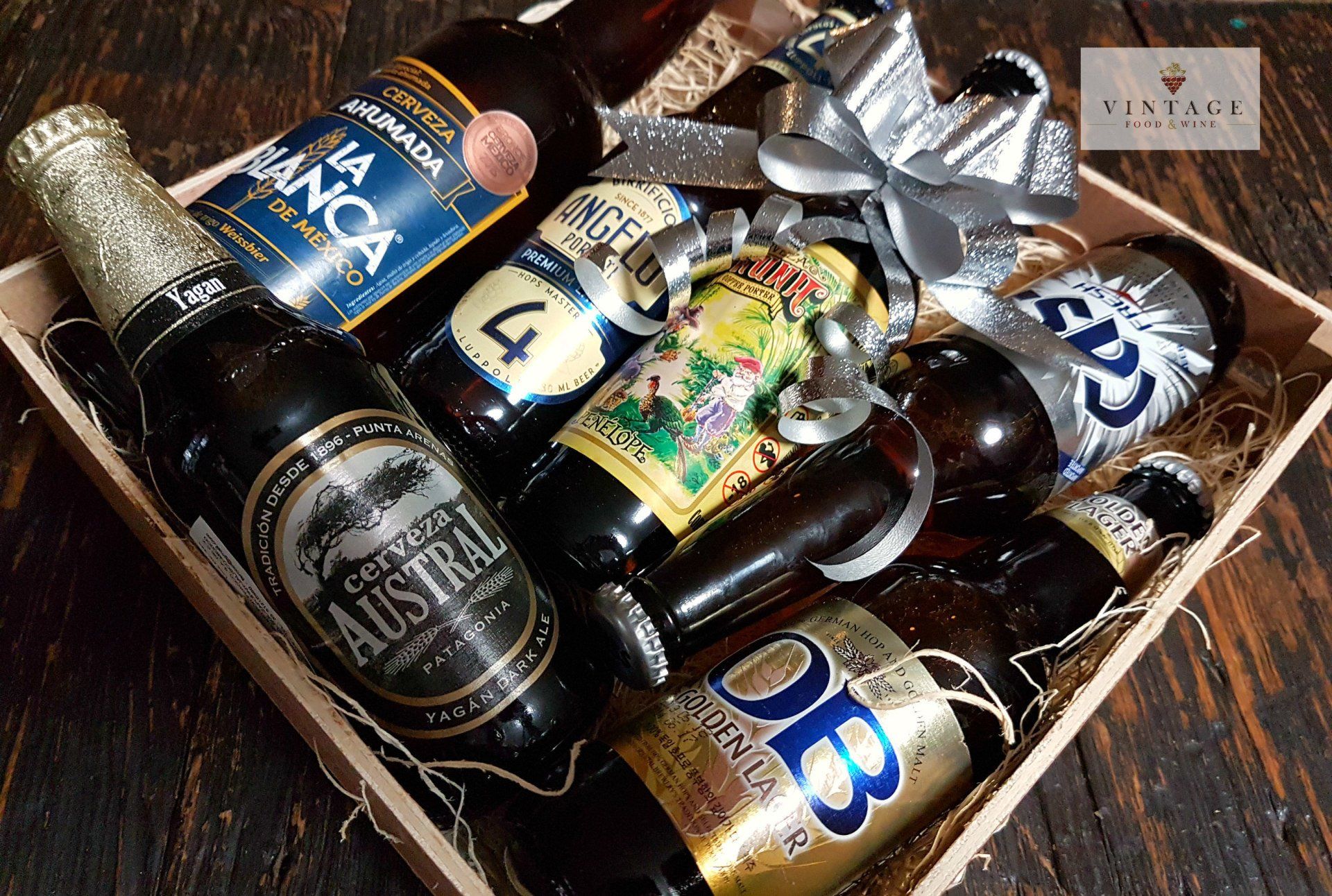 Una caja de madera llena de botellas y latas de cerveza.