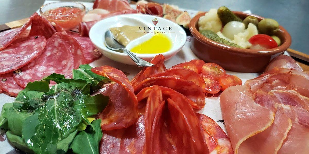 En una mesa hay una variedad de carnes y verduras.