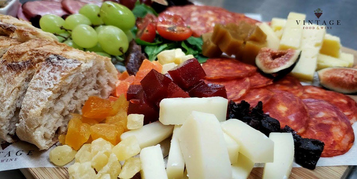 Una tabla de cortar de madera con una variedad de alimentos sobre ella.