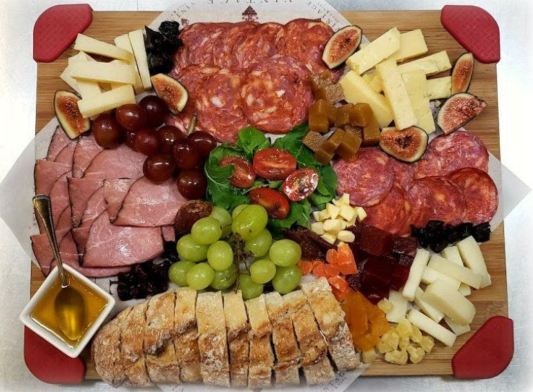 Una tabla de cortar de madera con una variedad de alimentos sobre ella.