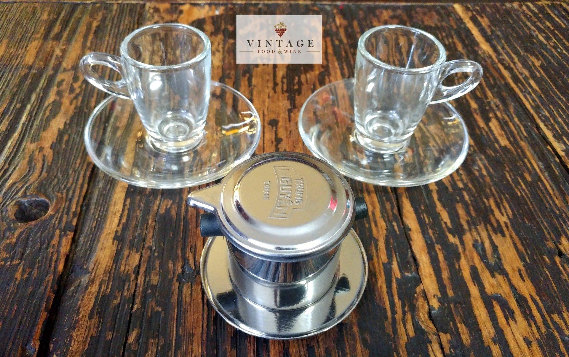 Dos tazas y platillos están sobre una mesa de madera.