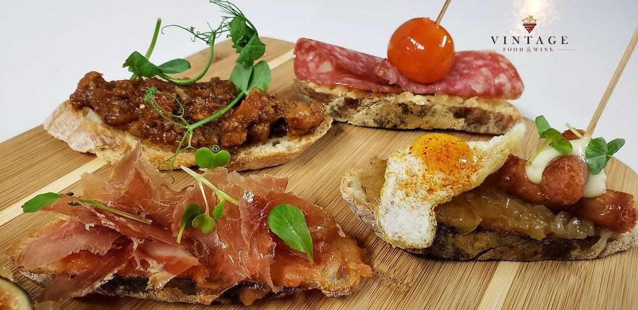 Una tabla de cortar de madera cubierta con una variedad de alimentos.