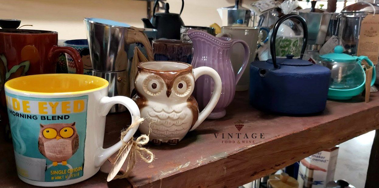 Un estante lleno de tazas de café y teteras.