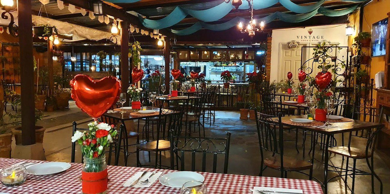 Un restaurante con mesas y sillas decoradas para el día de San Valentín.