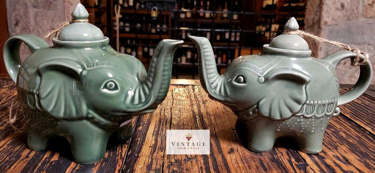 Dos teteras con forma de elefantes están sobre una mesa de madera.